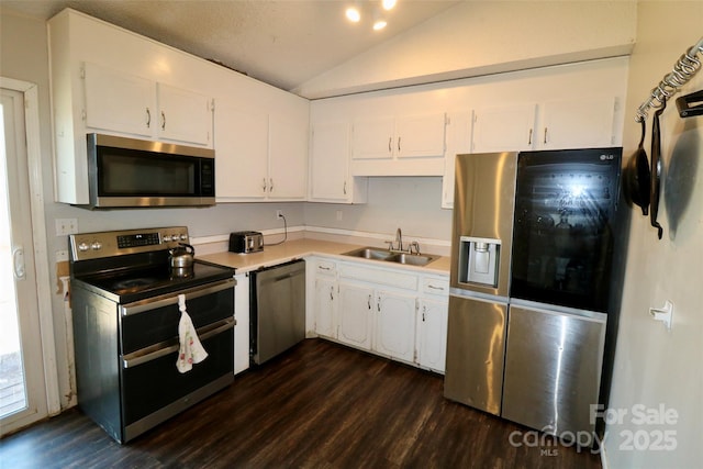 kitchen featuring stainless steel appliances, vaulted ceiling, white cabinetry, and a sink