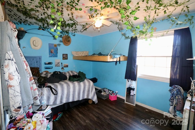 bedroom featuring a ceiling fan, baseboards, and wood finished floors