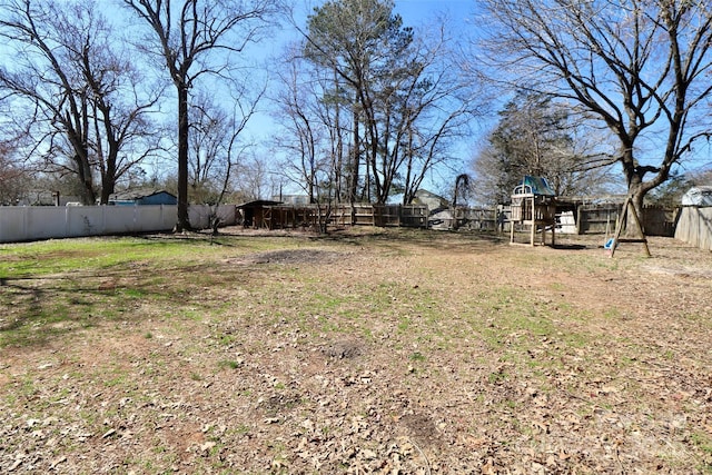 view of yard featuring a fenced backyard and a playground