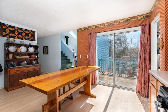 dining room featuring stairs and light wood-style flooring