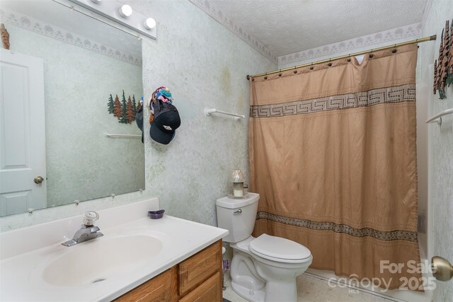 bathroom with curtained shower, wallpapered walls, toilet, vanity, and a textured ceiling
