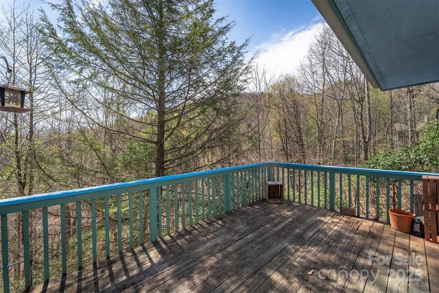 wooden deck featuring a view of trees