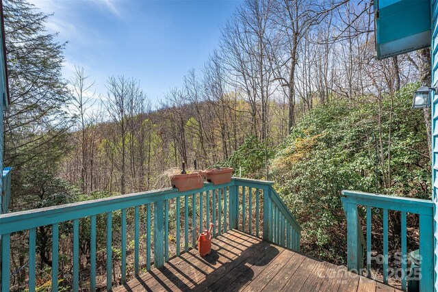 wooden deck featuring a view of trees