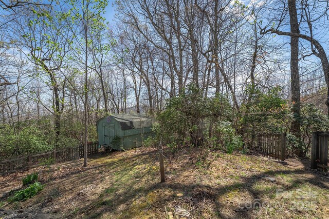view of yard with fence, an outbuilding, and a shed