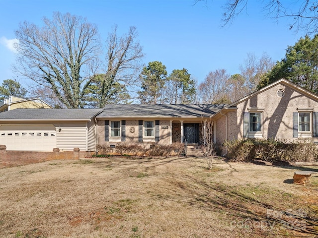 ranch-style home featuring a front lawn, brick siding, and an attached garage