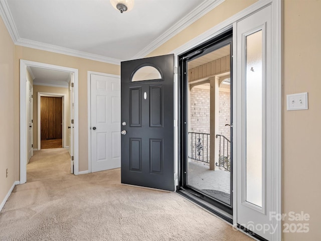 carpeted entryway featuring baseboards and crown molding