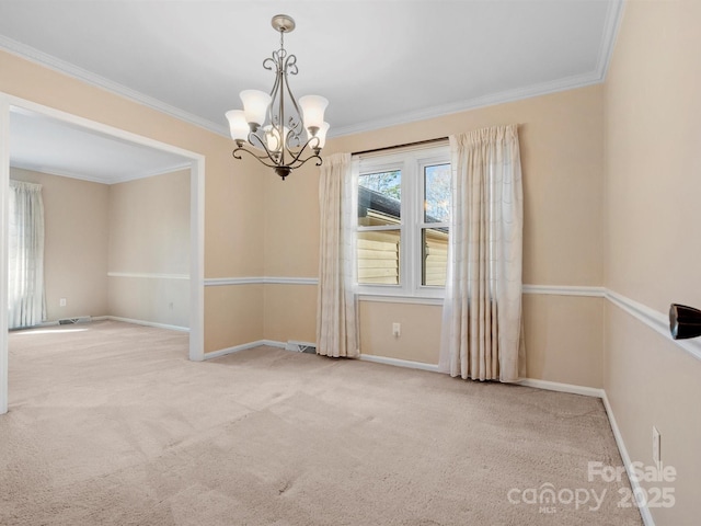 spare room with carpet floors, an inviting chandelier, baseboards, and ornamental molding