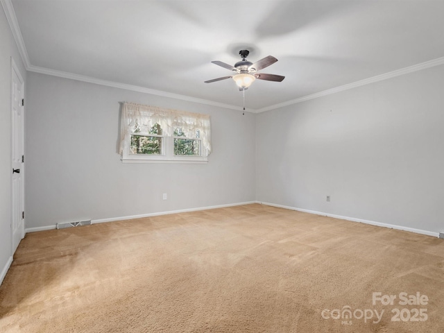 carpeted spare room featuring ornamental molding, visible vents, ceiling fan, and baseboards