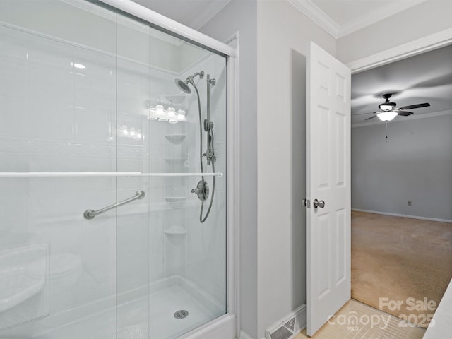 bathroom with ornamental molding, a shower stall, and a ceiling fan