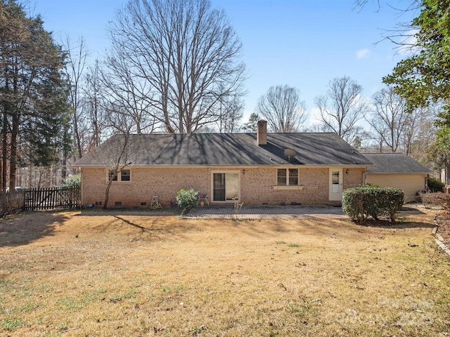 rear view of property featuring a lawn, a chimney, crawl space, fence, and brick siding