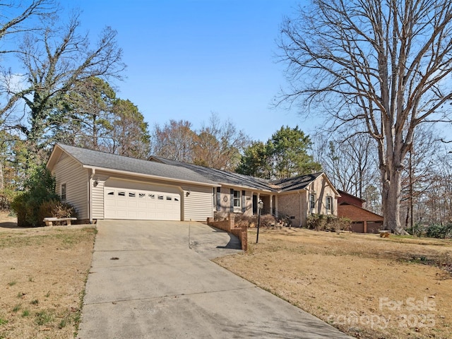 view of front of home with an attached garage, concrete driveway, and a front yard