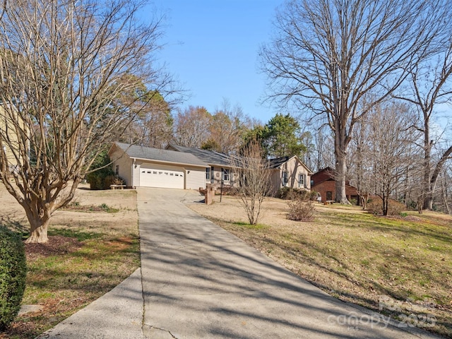 view of front of house featuring a garage, concrete driveway, and a front yard