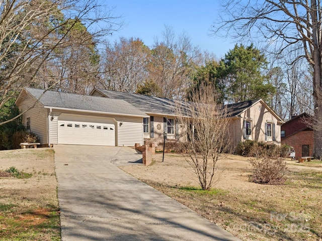 ranch-style house featuring concrete driveway and an attached garage