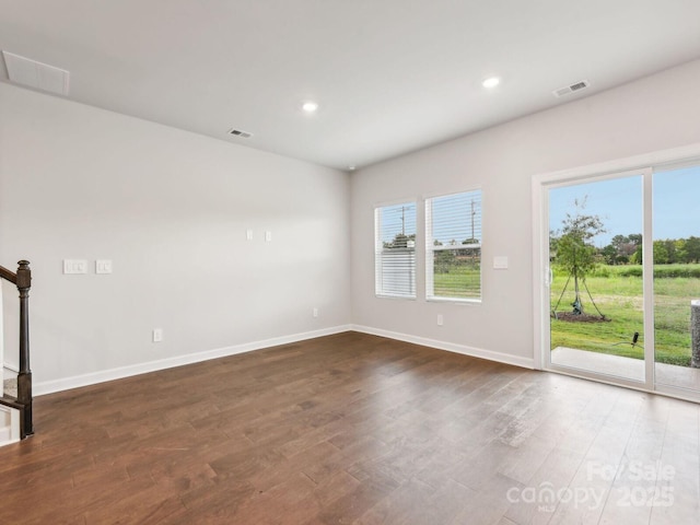 empty room with dark wood-type flooring, recessed lighting, visible vents, and baseboards