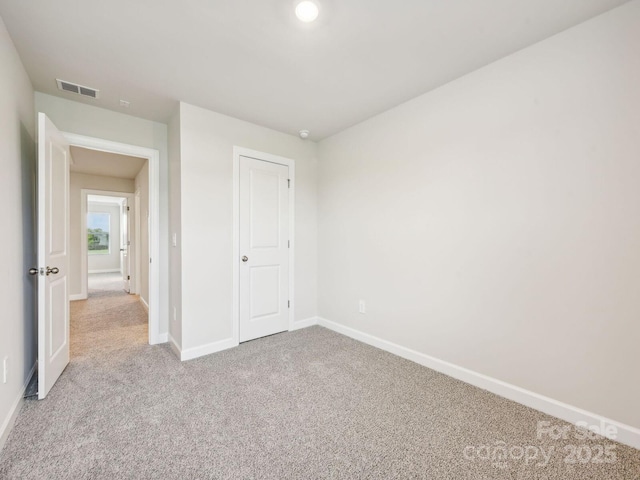 unfurnished bedroom featuring carpet, visible vents, and baseboards