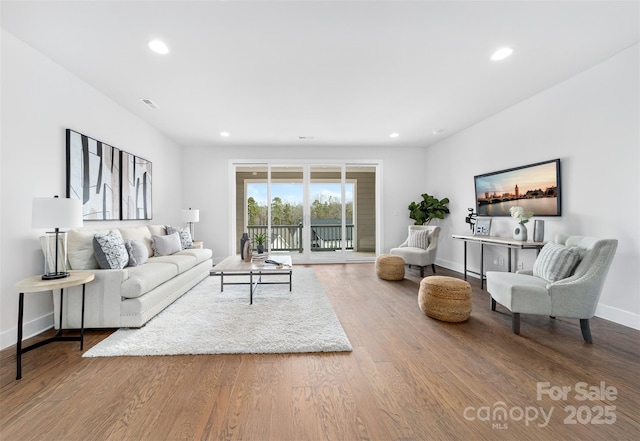 living room with recessed lighting, baseboards, and wood finished floors