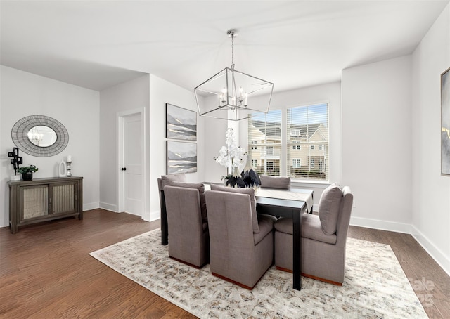 dining room featuring a chandelier, wood finished floors, and baseboards