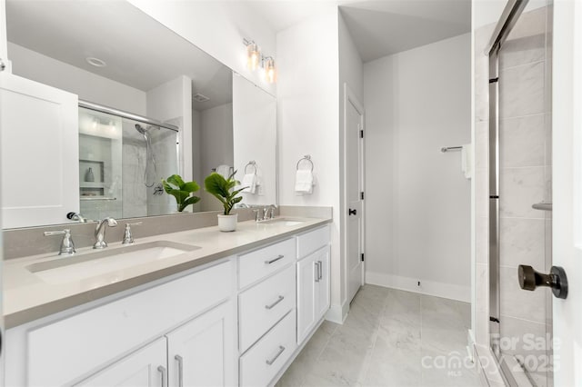 full bath with baseboards, double vanity, a sink, and a shower stall