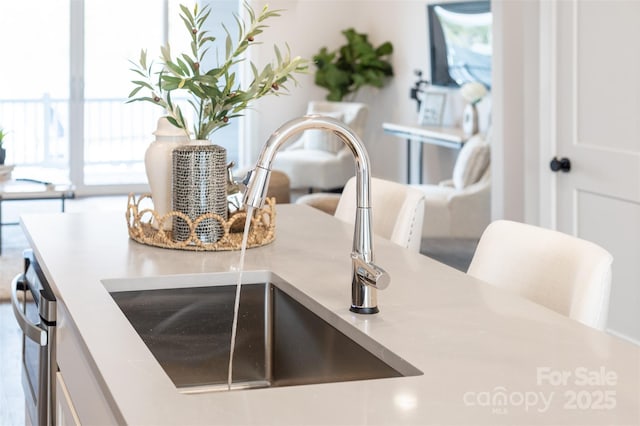 interior details with dishwashing machine, white cabinetry, light countertops, and a sink