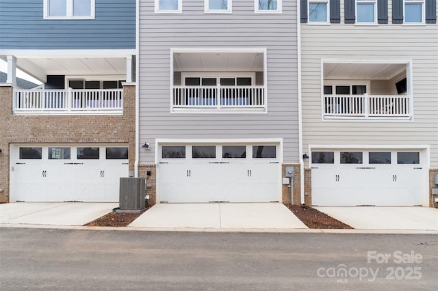 exterior space with central air condition unit, driveway, and a garage