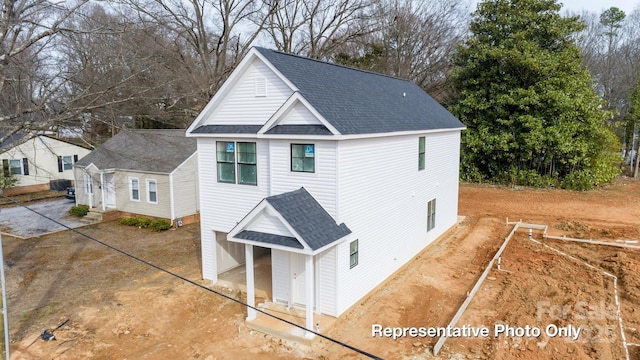 view of front of property with a shingled roof and driveway