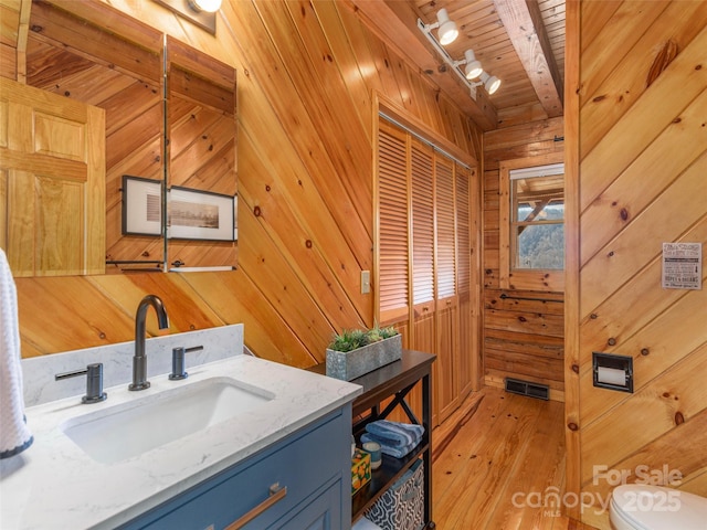 bathroom featuring wood ceiling, wood-type flooring, wooden walls, and vanity