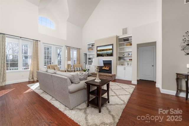 living area with a healthy amount of sunlight, a fireplace, and hardwood / wood-style floors