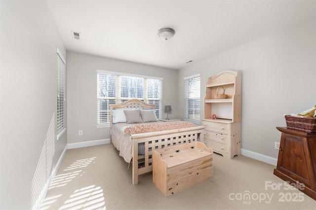 bedroom with visible vents, light carpet, and baseboards