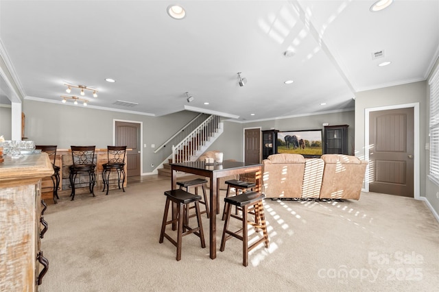 dining room with recessed lighting, light colored carpet, crown molding, and stairs