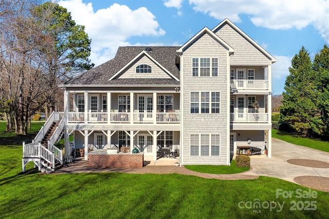 rear view of property with french doors, a yard, driveway, and a patio