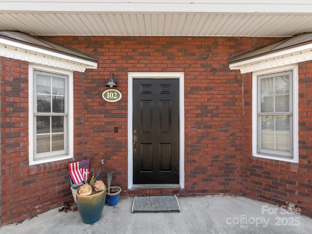 property entrance featuring brick siding