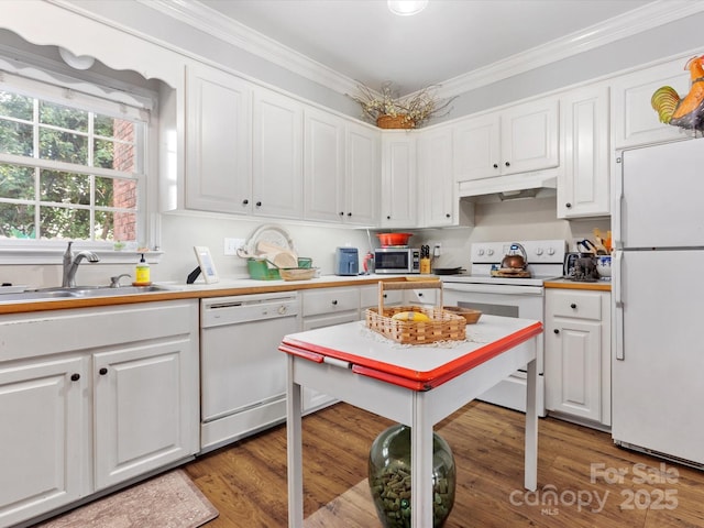 kitchen with under cabinet range hood, white appliances, a sink, white cabinetry, and crown molding