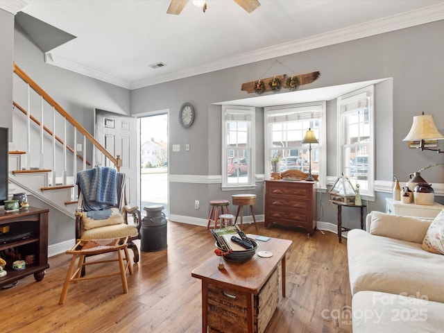 living area with plenty of natural light, wood-type flooring, stairs, and visible vents