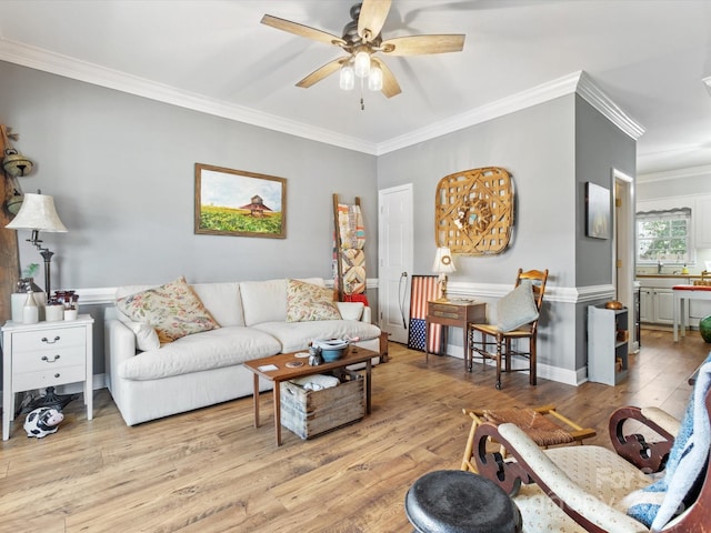 living area with crown molding, ceiling fan, and wood finished floors