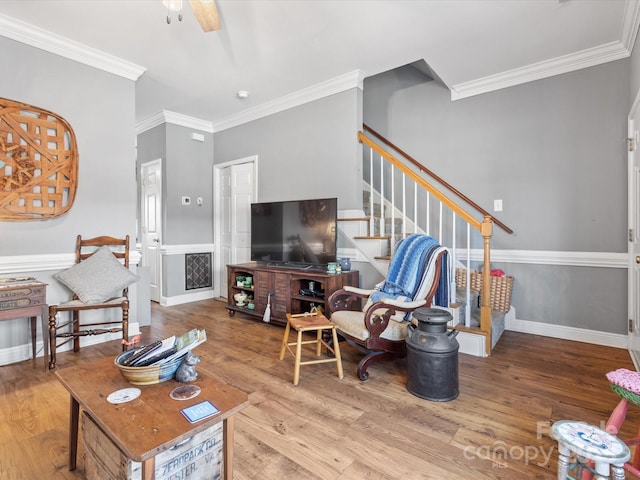 living room with ornamental molding, stairway, baseboards, and wood finished floors