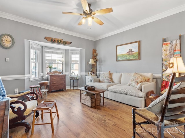 living room featuring ceiling fan, ornamental molding, and wood finished floors