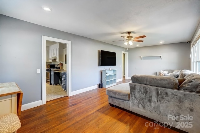 living room with ceiling fan, recessed lighting, light wood-style flooring, and baseboards