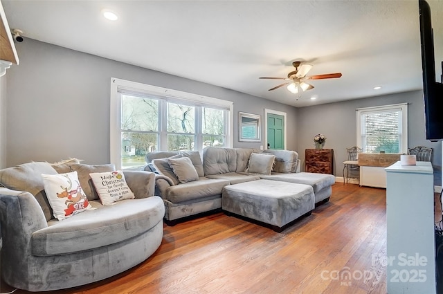 living room featuring baseboards, wood finished floors, a ceiling fan, and recessed lighting