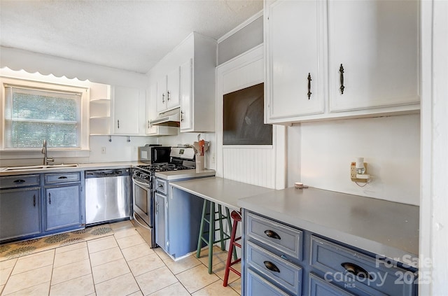 kitchen featuring open shelves, appliances with stainless steel finishes, a sink, and white cabinetry