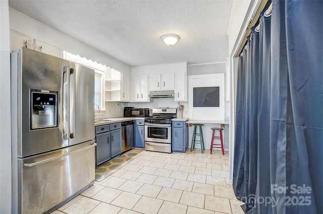 kitchen with under cabinet range hood, stainless steel appliances, a sink, white cabinetry, and open shelves