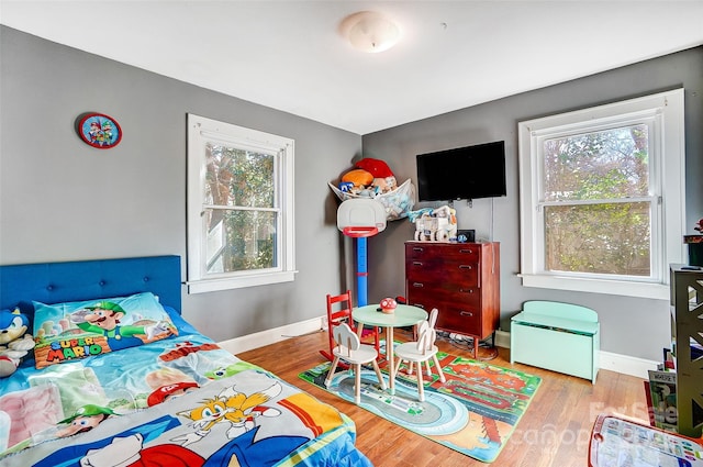 bedroom featuring baseboards and wood finished floors