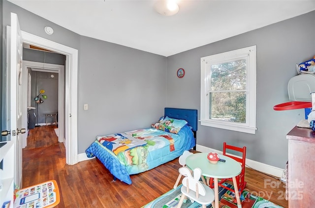 bedroom featuring baseboards and wood finished floors