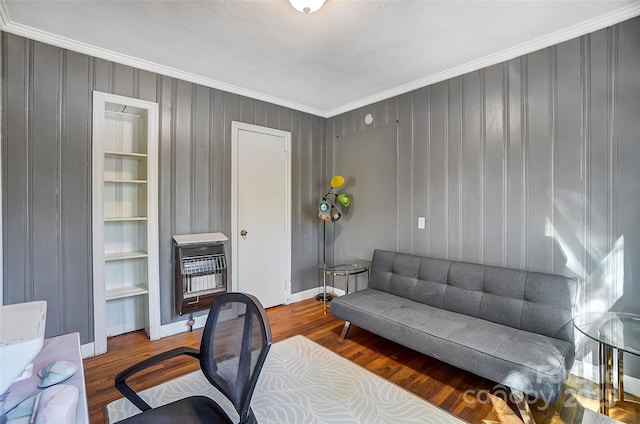 office space featuring heating unit, crown molding, baseboards, and wood finished floors