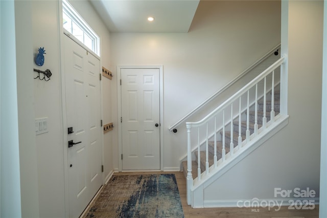 entrance foyer featuring recessed lighting, stairway, baseboards, and wood finished floors