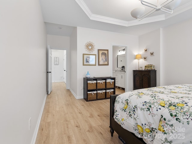 bedroom featuring ornamental molding, baseboards, light wood-type flooring, and connected bathroom