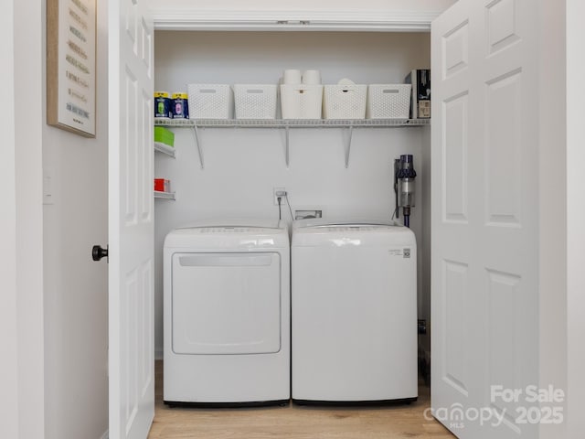 washroom with light wood-style flooring, washing machine and clothes dryer, and laundry area