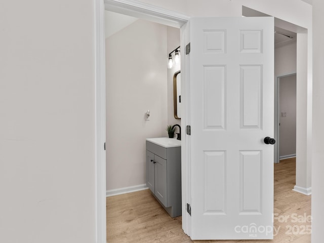 bathroom with vanity, baseboards, and wood finished floors