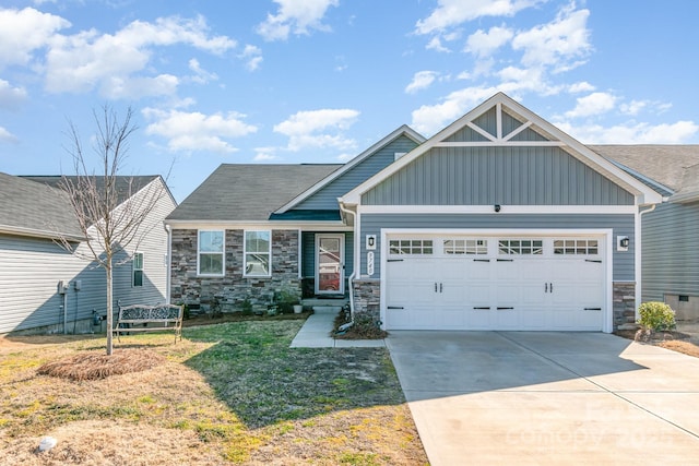 craftsman-style house featuring board and batten siding, a garage, stone siding, driveway, and a front lawn