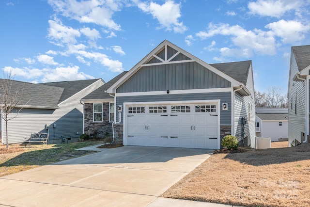 craftsman-style home featuring board and batten siding, stone siding, driveway, and a garage