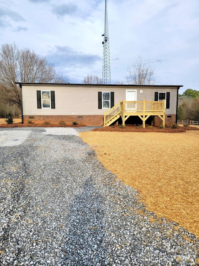 view of front of home featuring crawl space, driveway, and a deck